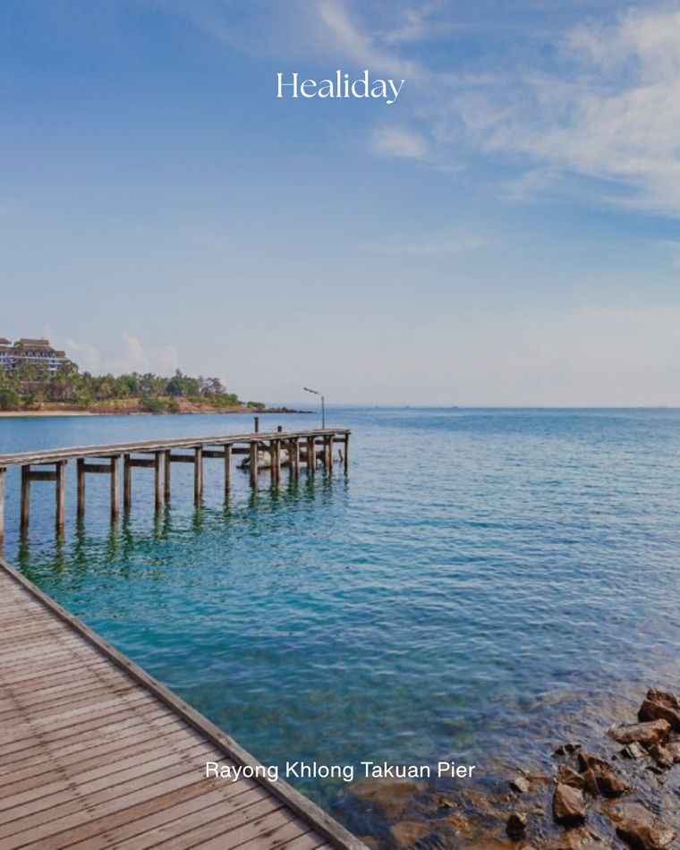 A long wooden pier reaching into calm sea at Khlong Takuan, Rayong
